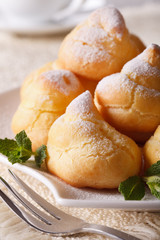 profiteroles with powdered sugar and mint close up, vertical