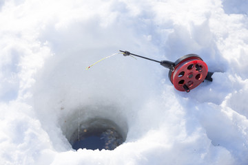 red rod and hole in  snow