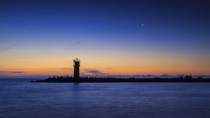 lighthouse with moon on the sky