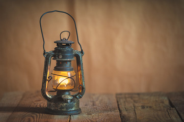 vintage kerosene oil lantern lamp burning with a soft glow light - obrazy, fototapety, plakaty