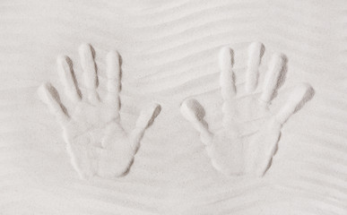 Zwei Hände im Sand am Strand im Sommer als Hintergrund