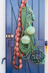 Fishermans rope and floats hanging on a blue door