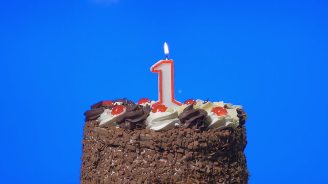 Blowing out number one birthday candle on a chocolate cake
