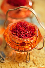 saffron spice in antique vintage glass bowl, closeup - 80701641