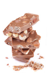 Stack of milk chocolate with hazelnuts on white background