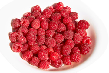 Raspberries on a plate over white