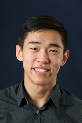 Young Asian man smiling and looking at camera - obrazy, fototapety, plakaty