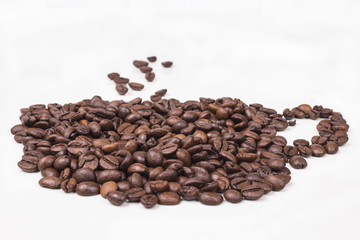 scattered whole grains of black coffee in a cup shape