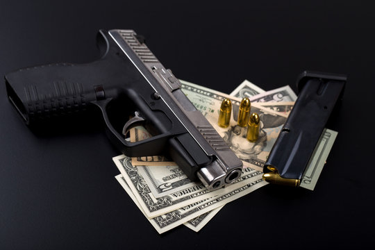 gun with bullet on US dollar banknotes