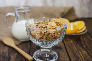 granola in a glass bowl and milk in a jug
