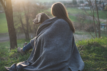 Woman with her beautiful dog lying outdoors