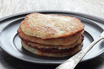 Five pieces of potato pancakes on a tin plate.