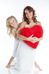 Mother with daughter with big red heart in studio