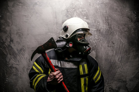 Firefighter in uniform on grey background