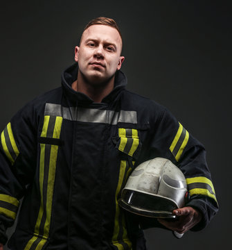 Firefighter in uniform on grey background