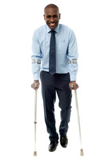 Middle aged man walking with two crutches