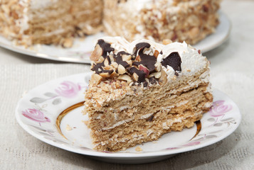 Cake with honey shortcakes, curd cream with nuts and chocolate.