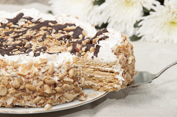 Cake with honey shortcakes, curd cream with nuts and chocolate.