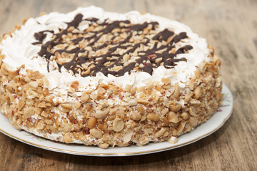 Cake with honey shortcakes, curd cream with nuts and chocolate.