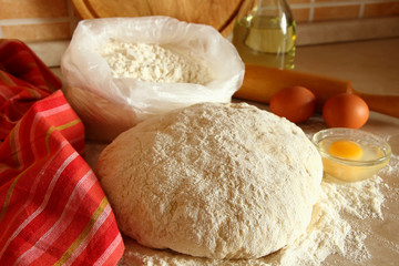 Yeast dough, eggs, and flour on the table.