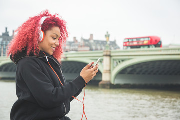 Obraz premium Beautiful woman listening music in London