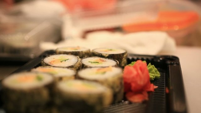 Close up of sushi chef puts in a container for sale In Japanese