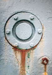 Round gray rusted cover mounted with bolts