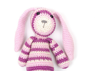 Funny knitted rabbit toy portrait over white wall