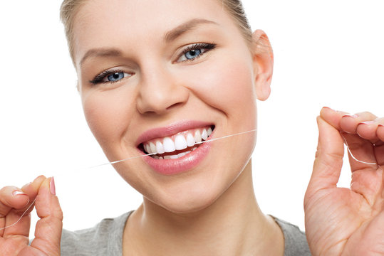 Young woman flossing teeth. Dental care and protection concept.