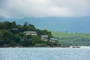 View of Seychelles coastline with houses in the forest