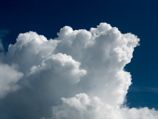 White cumulus cloud over dark blue sky