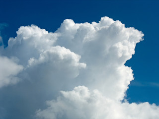 Obraz premium White cumulus cloud over dark blue sky