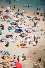 Fototapeta na wymiar People and sun umbrellas on the beach