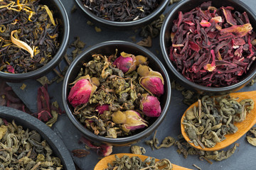 assortment of fragrant dry tea in ceramic bowls, close-up
