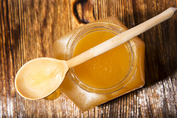 jar of honey and spoon on a wooden background