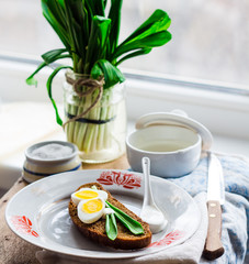leek with quail eggs and sour cream on rye bread, snack