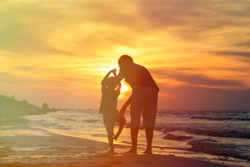 Fototapeta premium father and son doing yoga at sunset sea