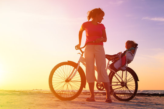mother and baby biking at sunset