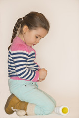 Little girl playing with spool, studio shot on white background