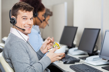 Male Customer Service Representative Having Food In Office
