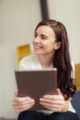 Fototapeta premium lachende junge frau hält tablet-pc in der hand