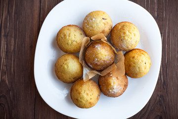 Homemade muffins in plate on wood table