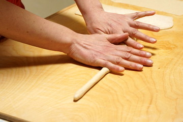Detail of the hands of an Italian woman making home made pasta