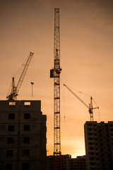 Background of  silhouette building crane lift loads with sun set