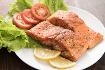 Grilled salmon fillet cooked BBQ and served with fresh herbs and