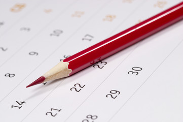 Red pencil over calendar