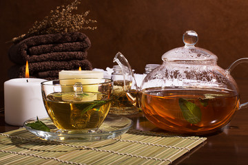 SPA still life: green tea, aromatic oil, towels