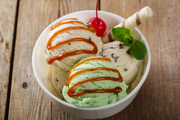 ball pistachio and white ice cream in  bowl with caramel
