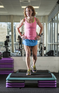 muscular woman doing step aerobics