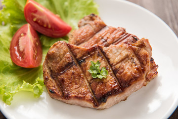 Grilled steak with vegetables on a dish.